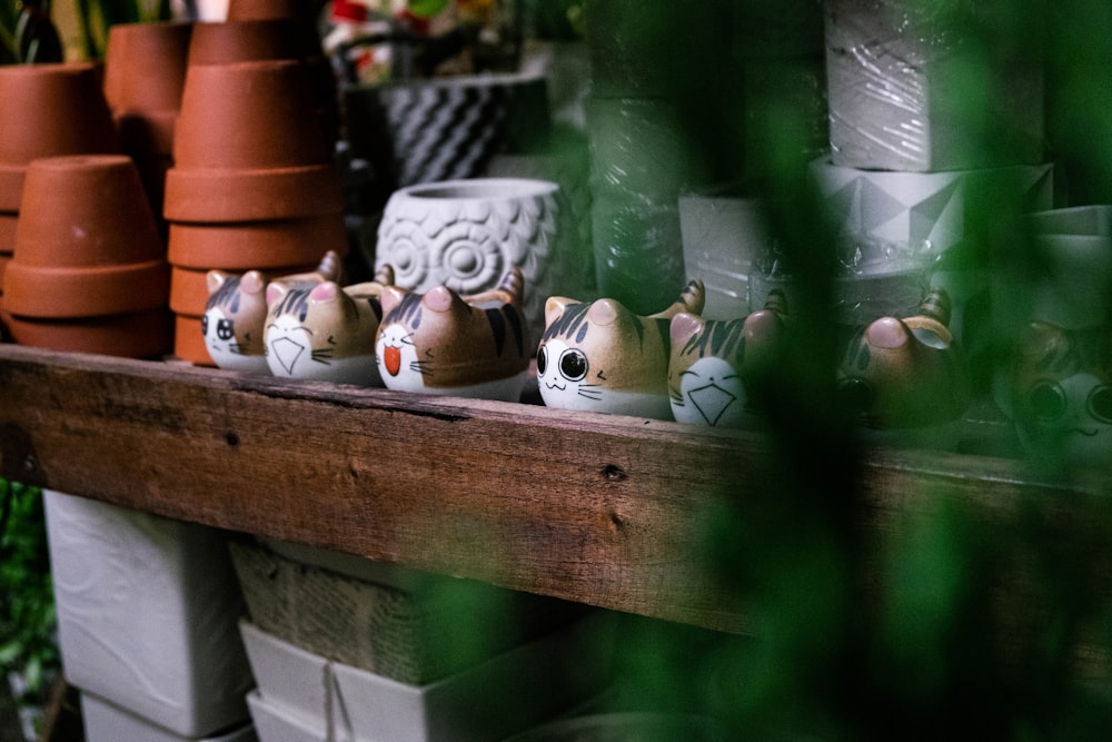 a shelf filled with clay pots and plants