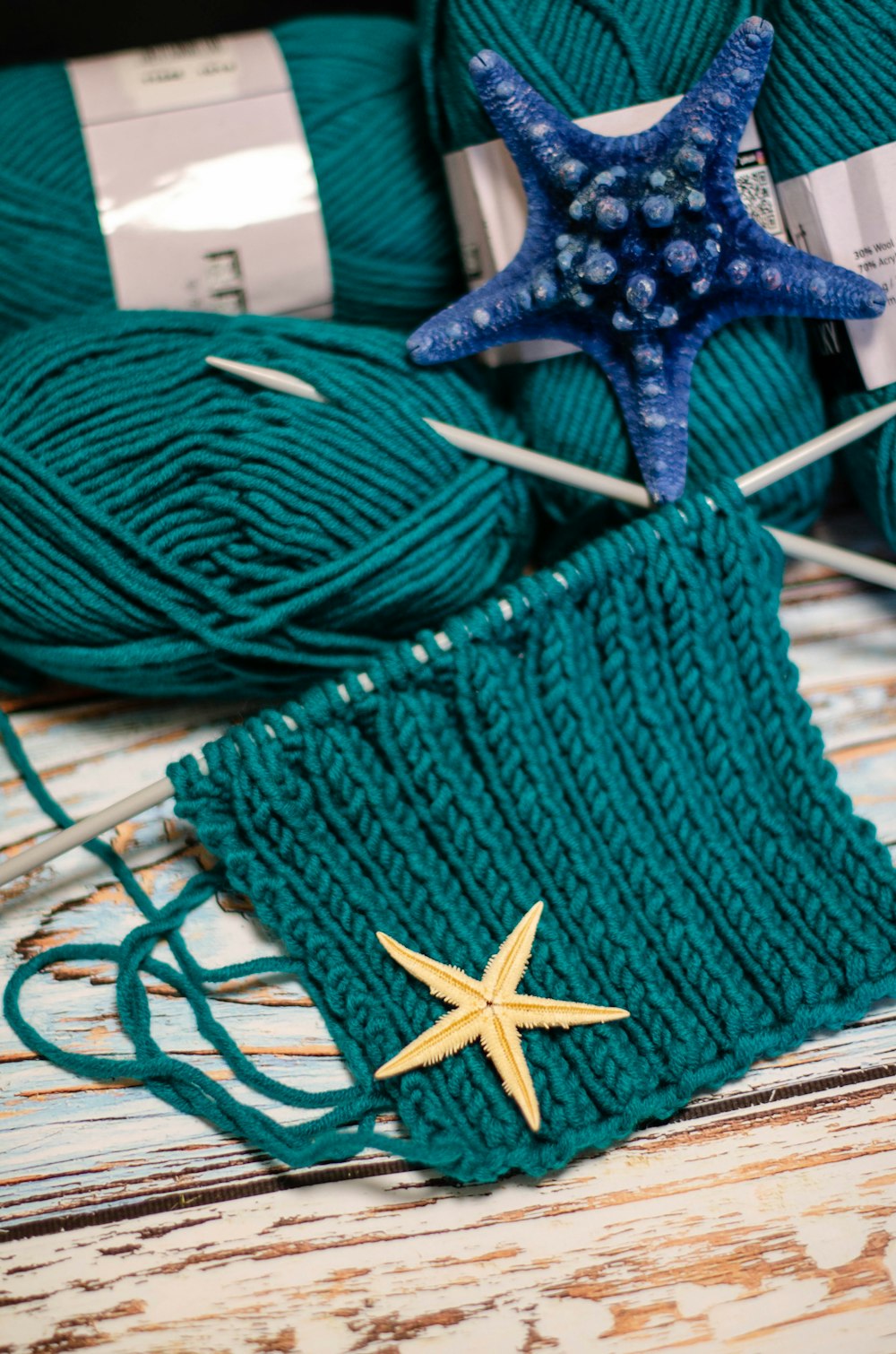 a green knitted bag with a starfish on top of it