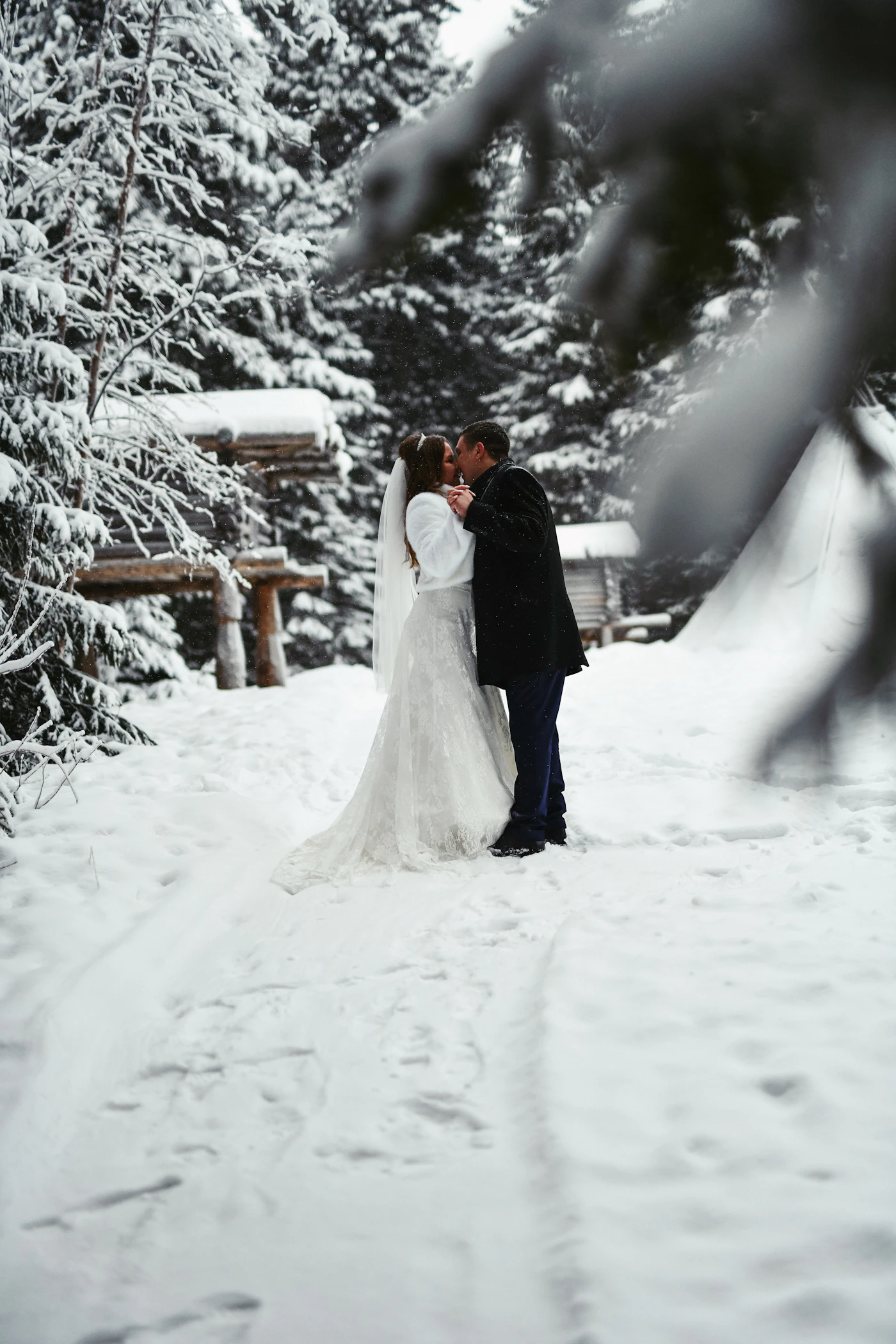 Winter wedding cape styles for cold climates — Close-up of a faux fur bridal cape draped over a wedding dress.