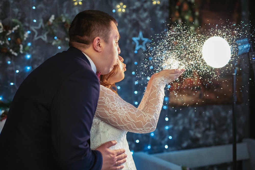 a bride and groom kissing in front of a christmas tree