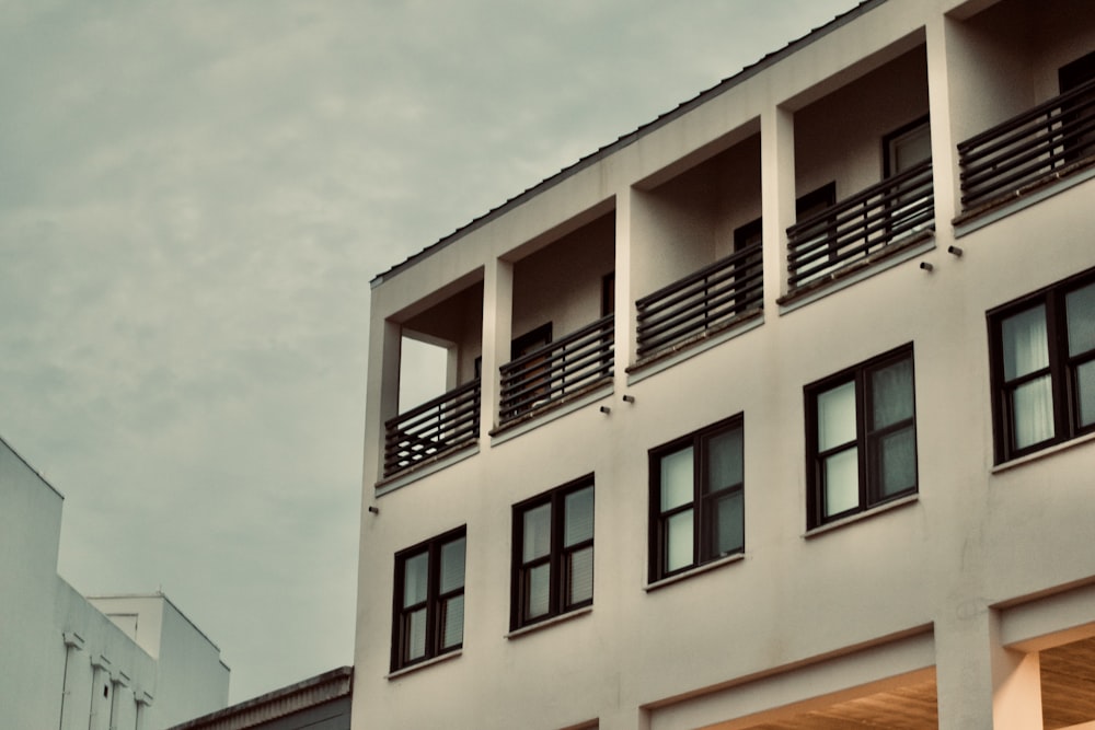 a tall white building with balconies and windows