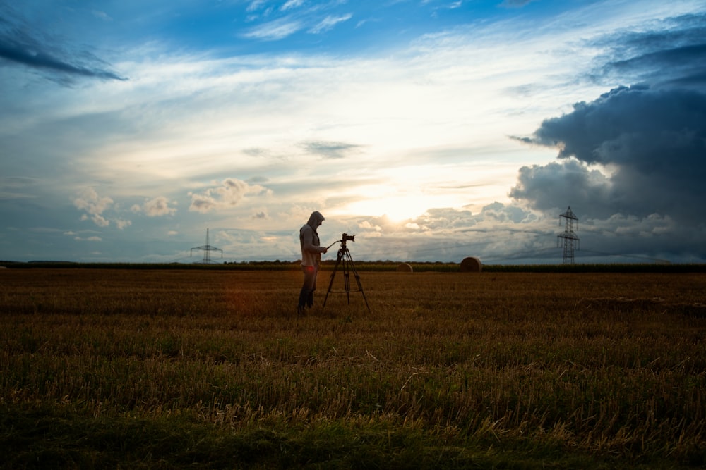 a person standing in a field with a camera