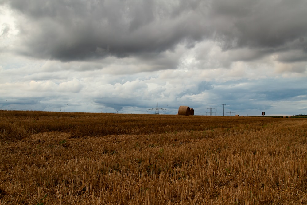 a field with a hay bail in the middle of it