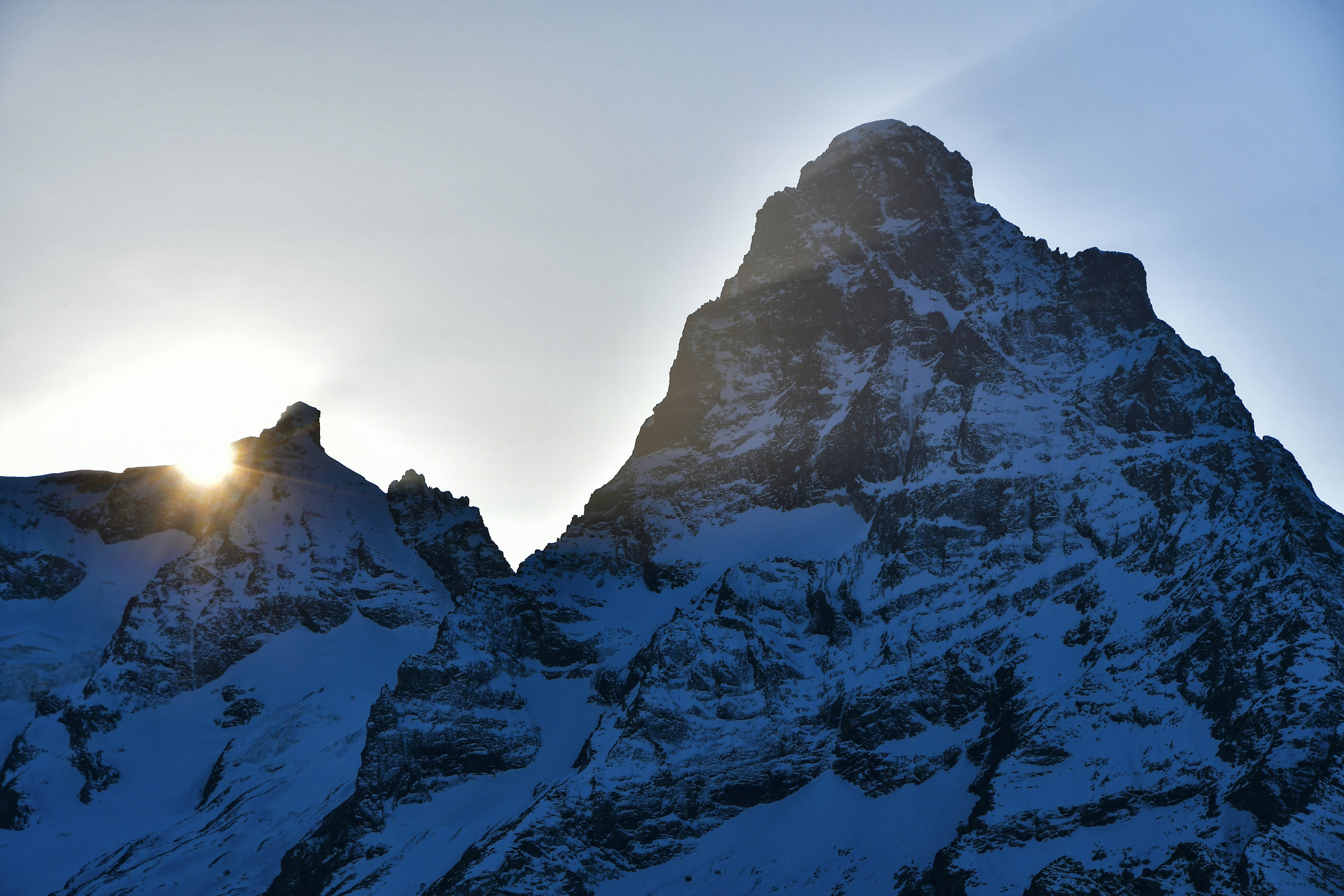 солнце пробивается сквозь облака над горами