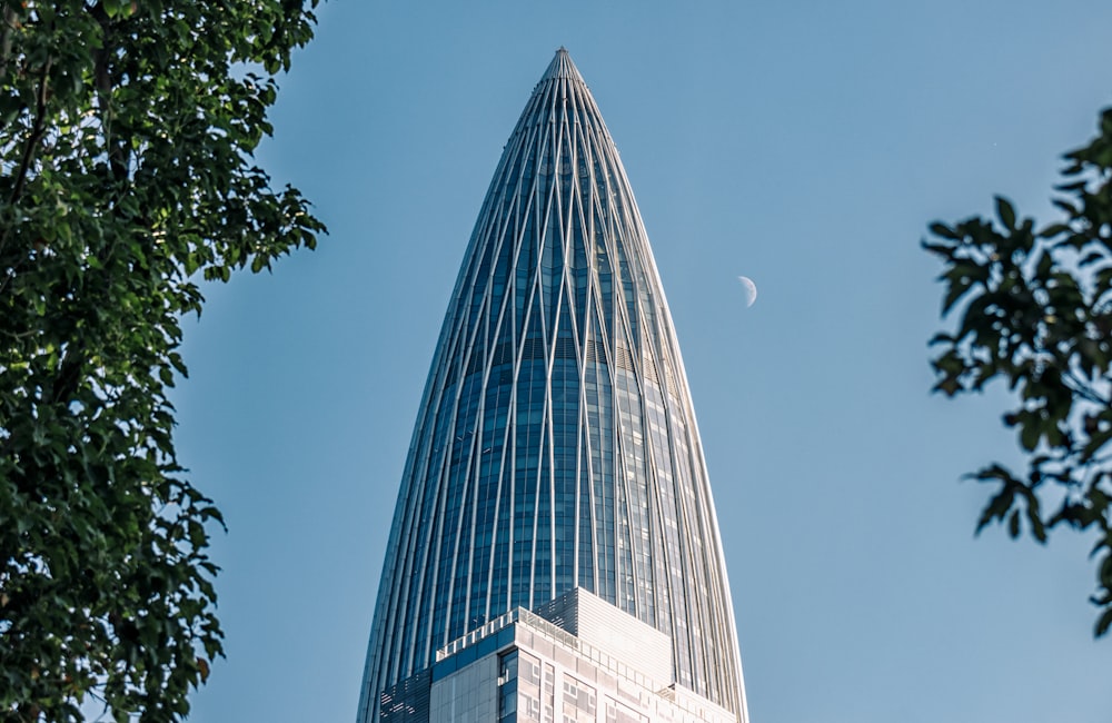 a very tall building with a half moon in the sky