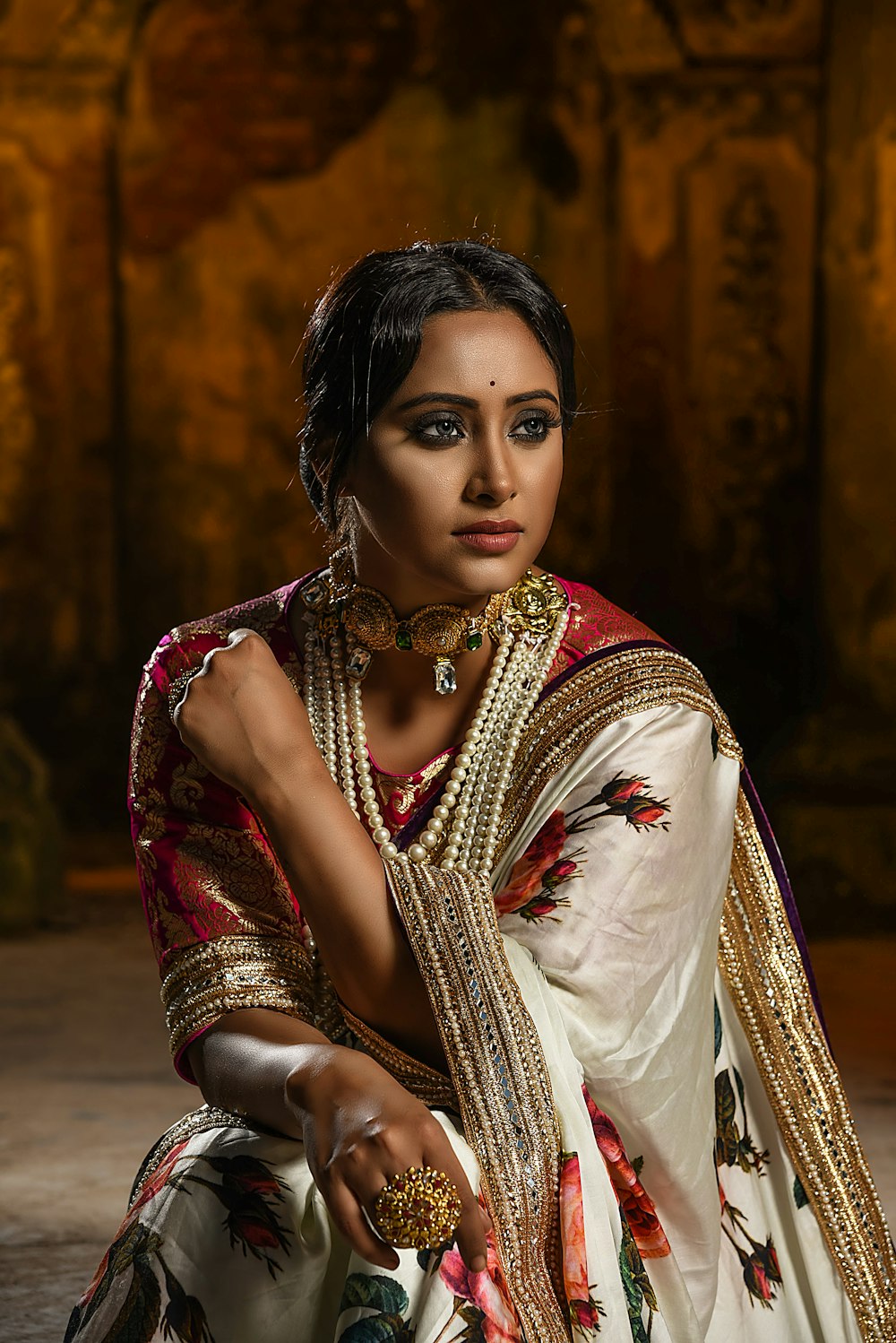 a woman in a white sari with gold jewelry