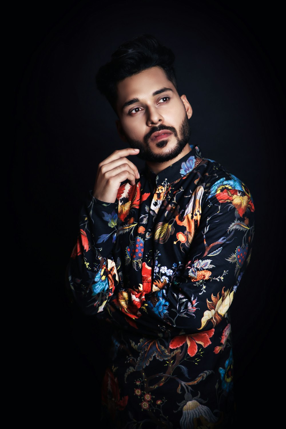 a man in a floral shirt posing for a picture