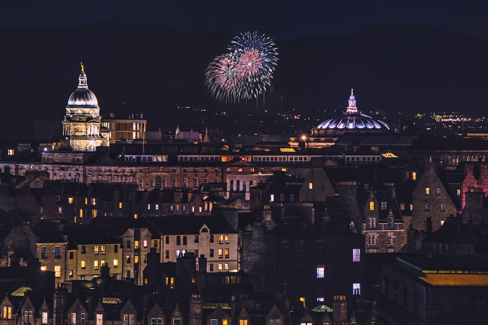 fireworks are lit up the night sky over a city