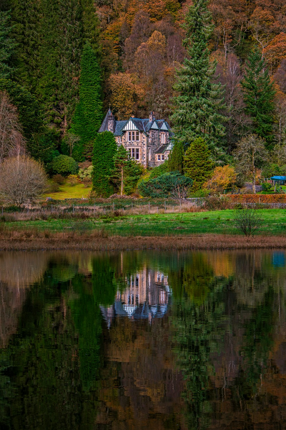 a large house sitting on top of a lush green hillside