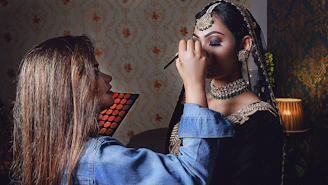 Makeup artist applying elegant eye makeup during a home function.