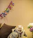 A stylish cat lounging on a bright cushion, dressed in a vibrant, handmade outfit.