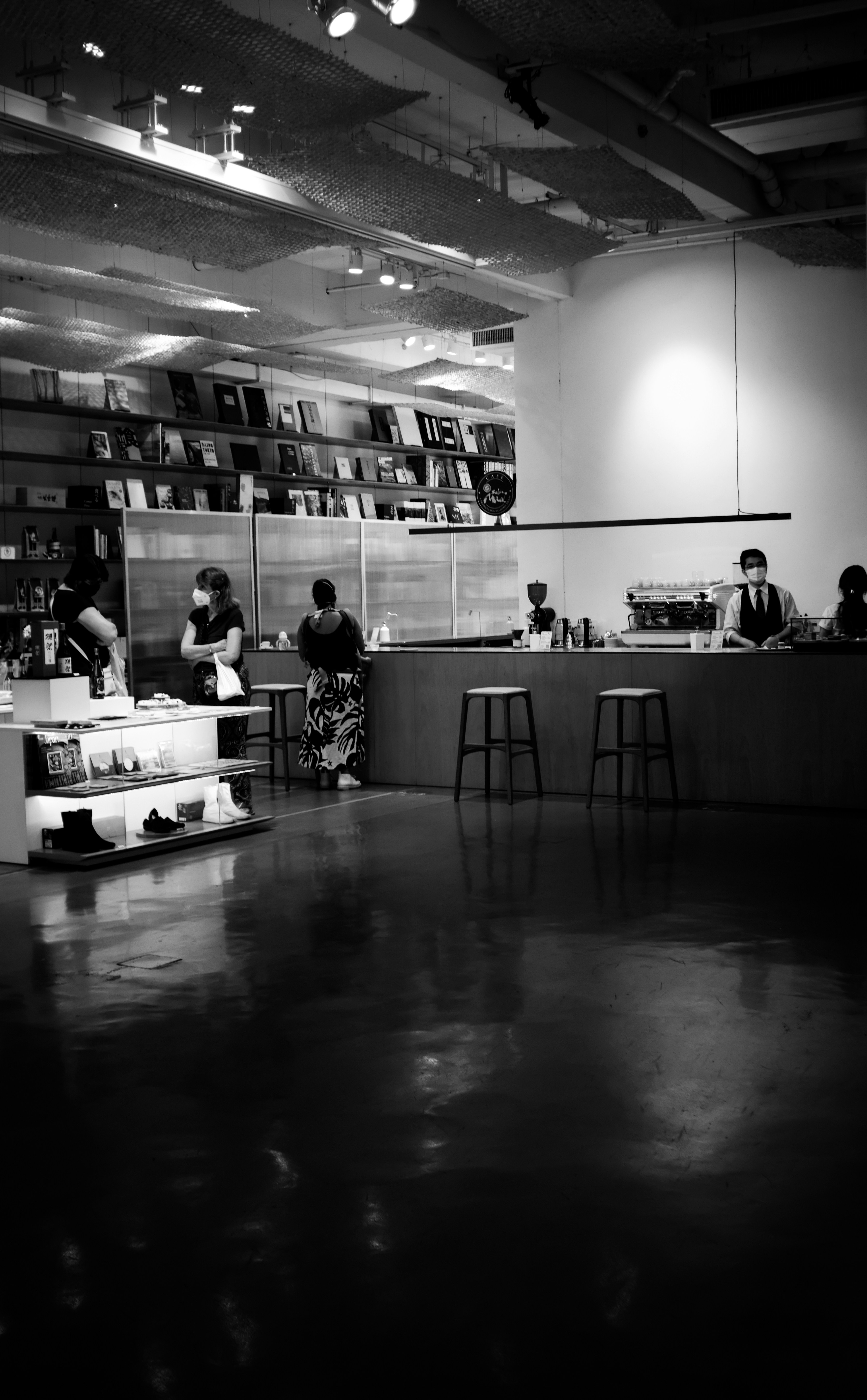 a black and white photo of people sitting at a counter