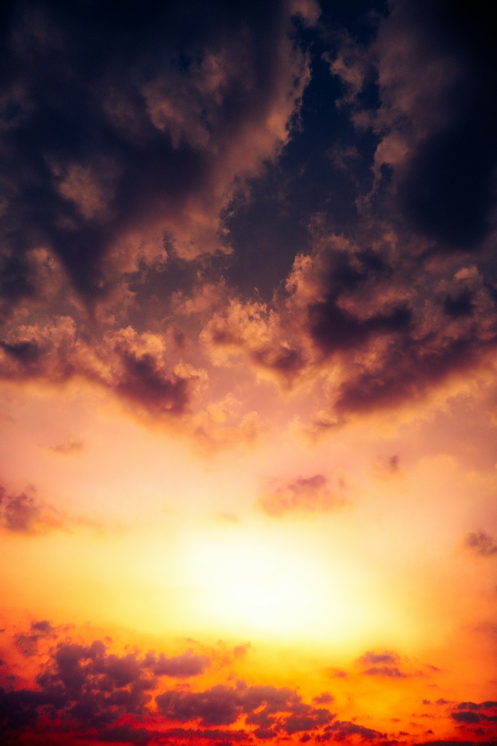 a plane flying in the sky at sunset