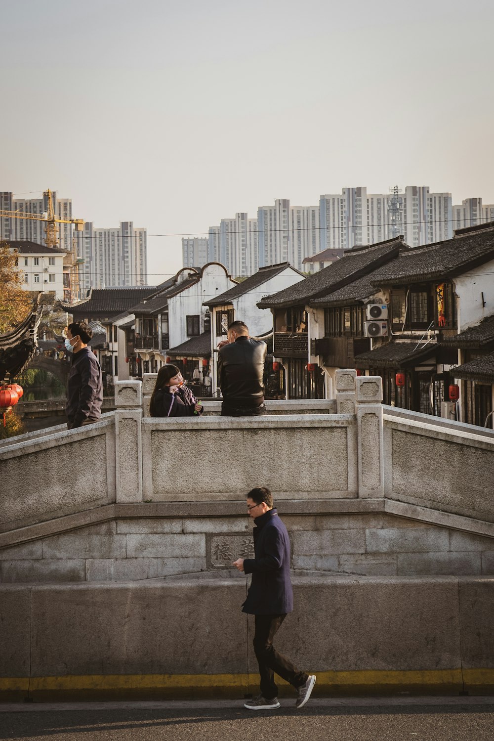 a man walking down a street next to a bridge