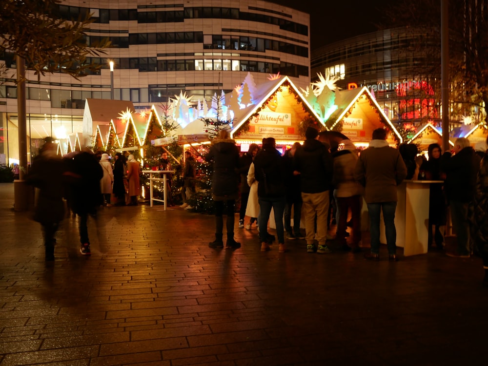 a group of people standing around a christmas market