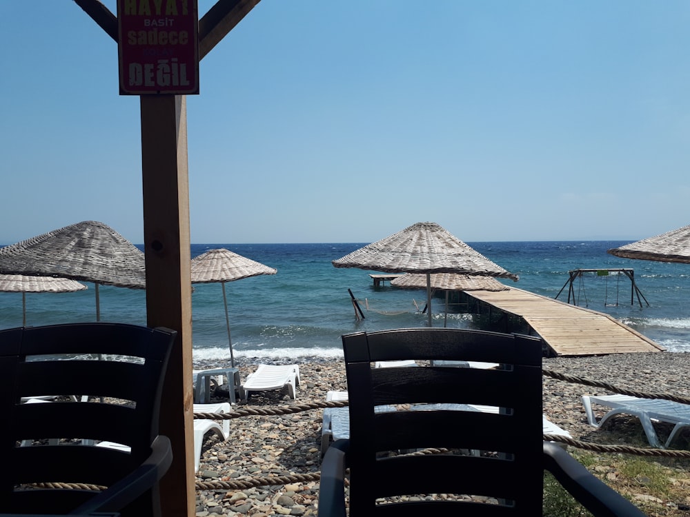 chairs and umbrellas on a beach near the ocean