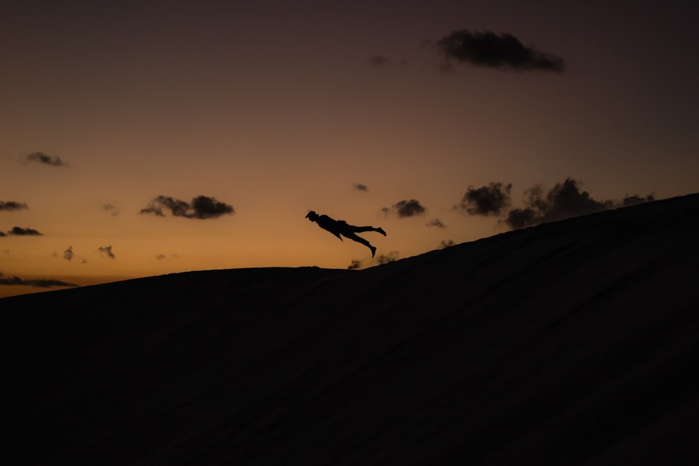 a person jumping in the air at sunset