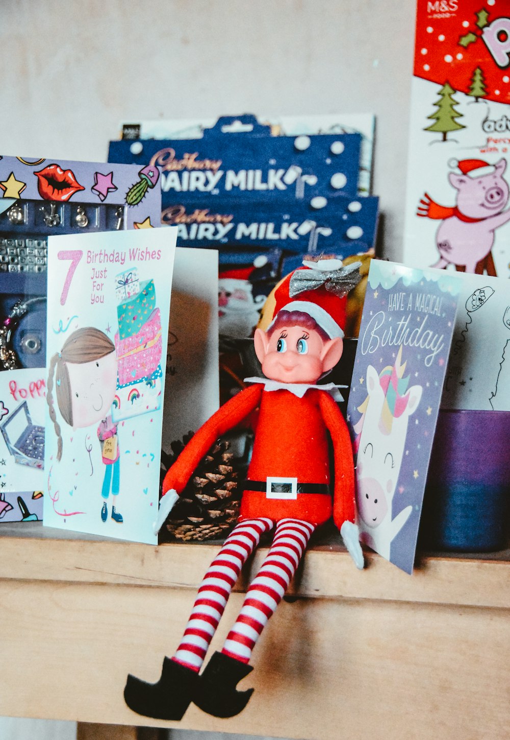 a elf sitting on top of a wooden shelf