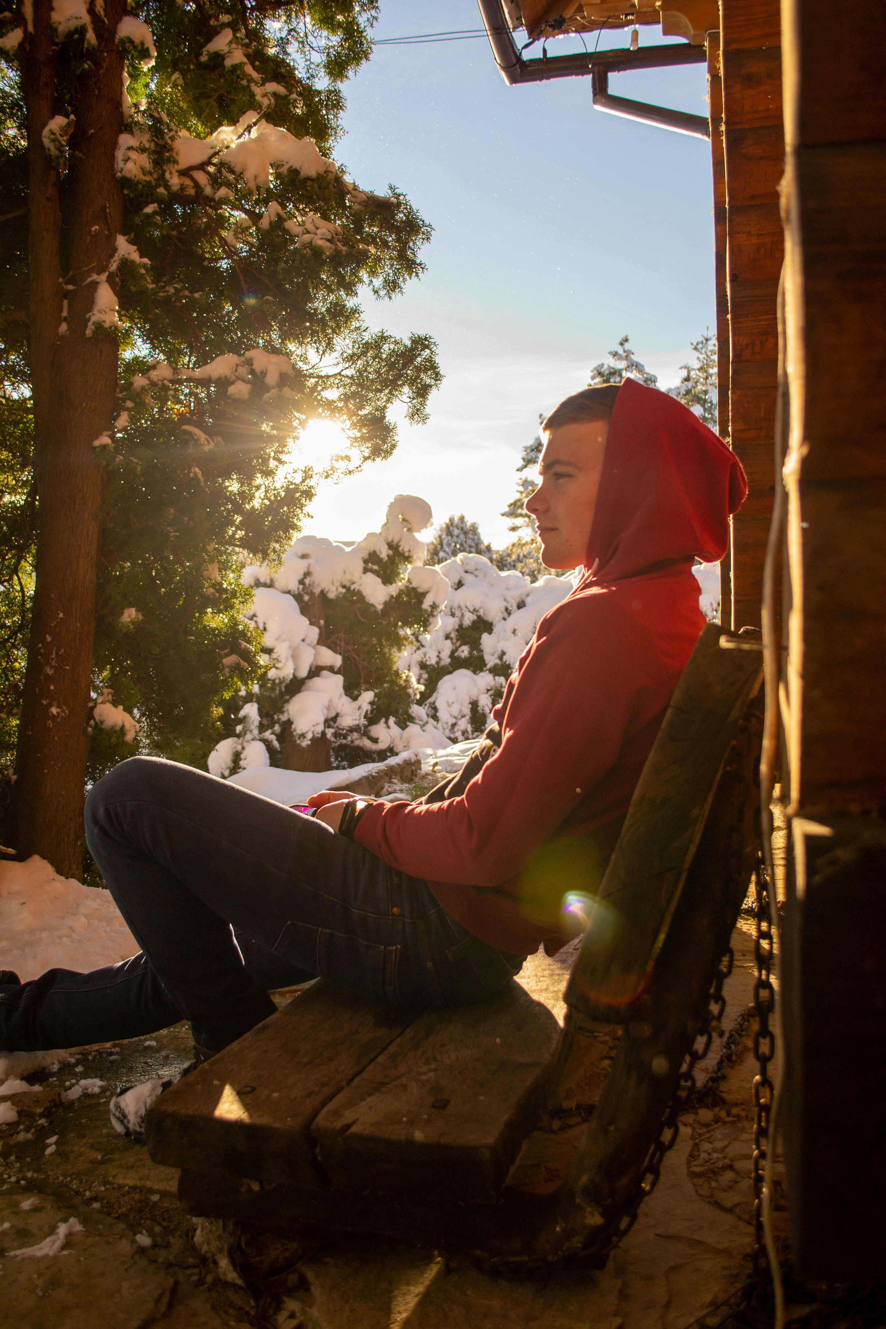 Eine Frau im roten Kapuzenpulli sitzt auf einer Bank