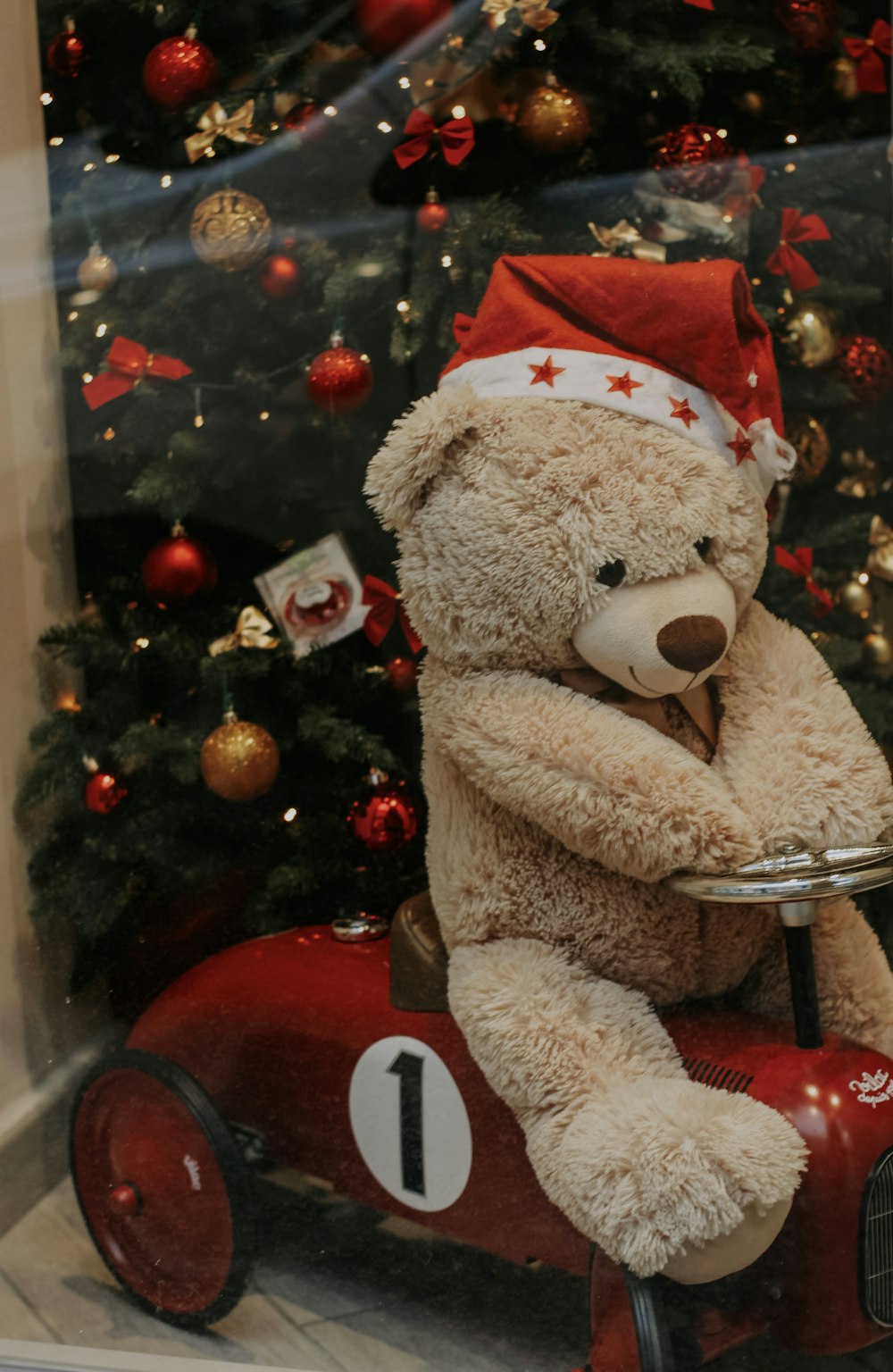 a teddy bear sitting on top of a toy car