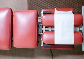 a row of red chairs with a white stripe on them