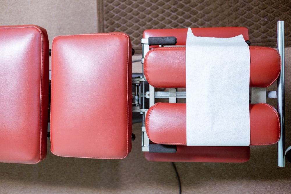 une rangée de chaises rouges avec une bande blanche