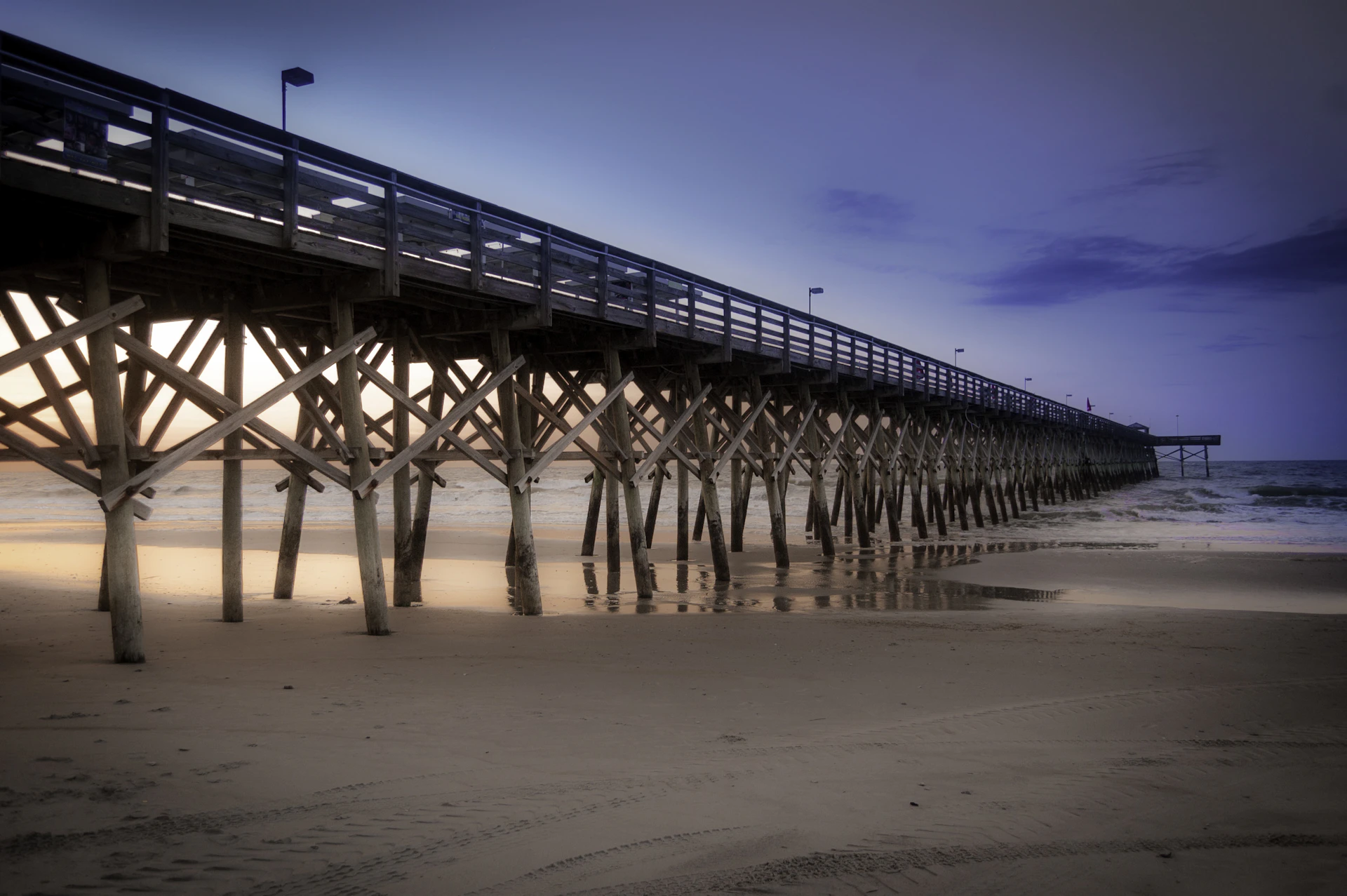 a long pier stretches out into the ocean