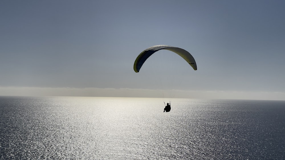 a parasailer in the middle of the ocean on a sunny day