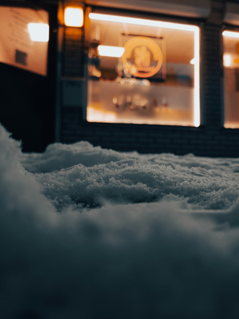 a snow covered sidewalk in front of a store