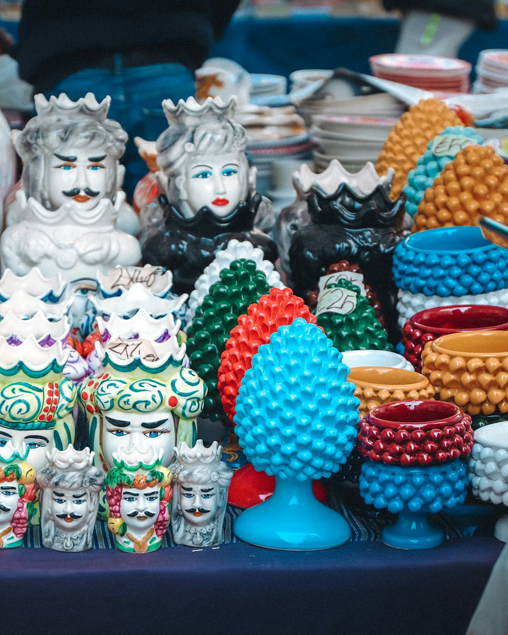 a table topped with lots of colorful ceramic figurines