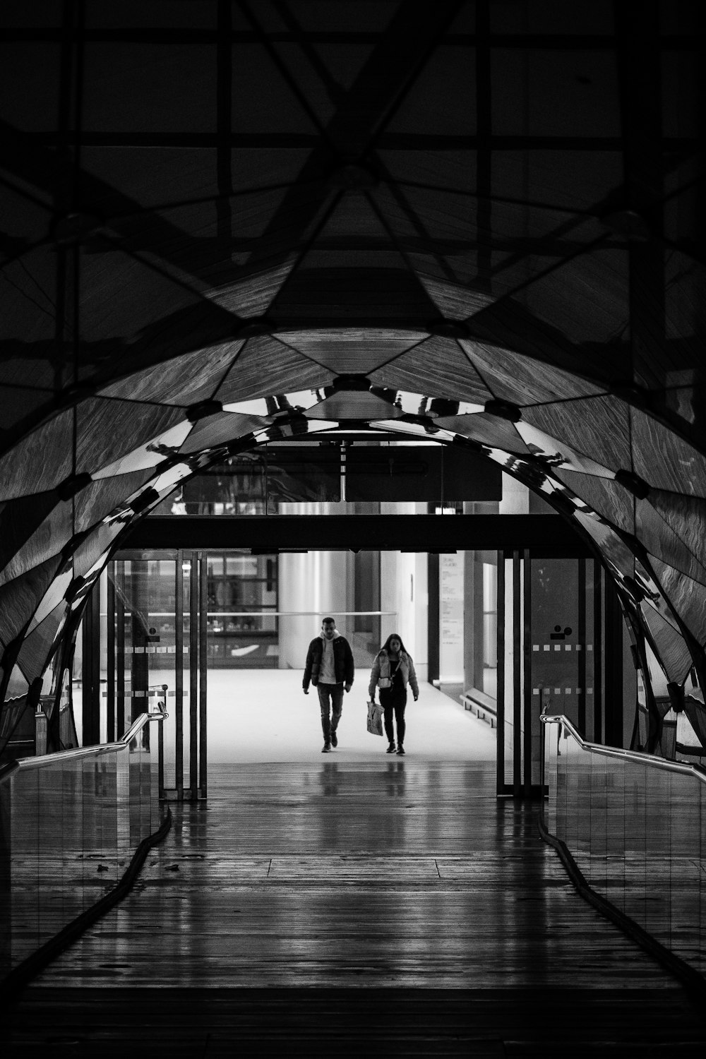 a couple of people walking down a walkway