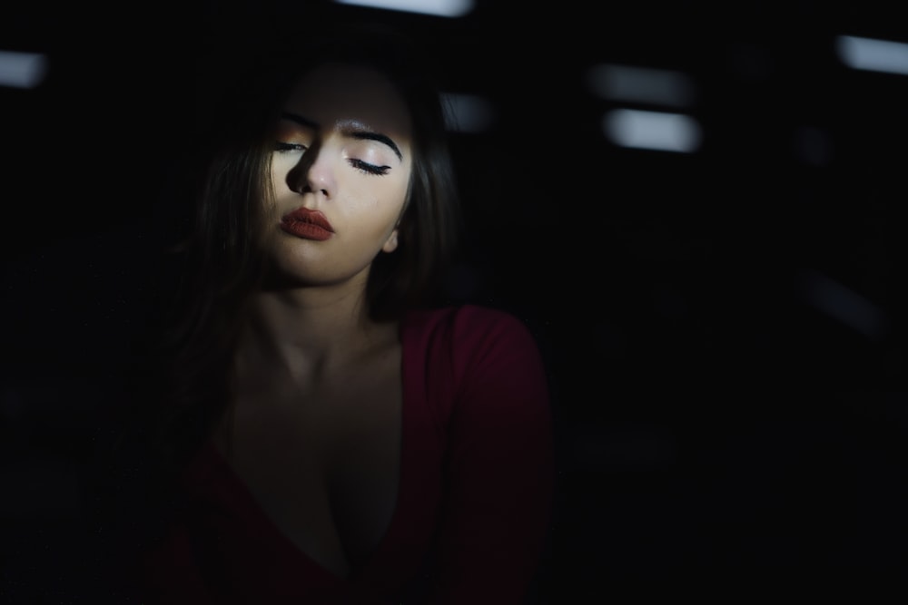 uma mulher com os olhos fechados no escuro