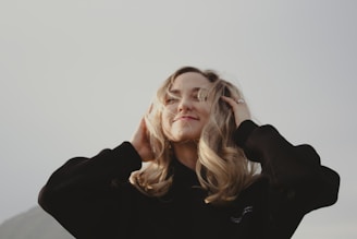 a woman with blonde hair wearing a black shirt