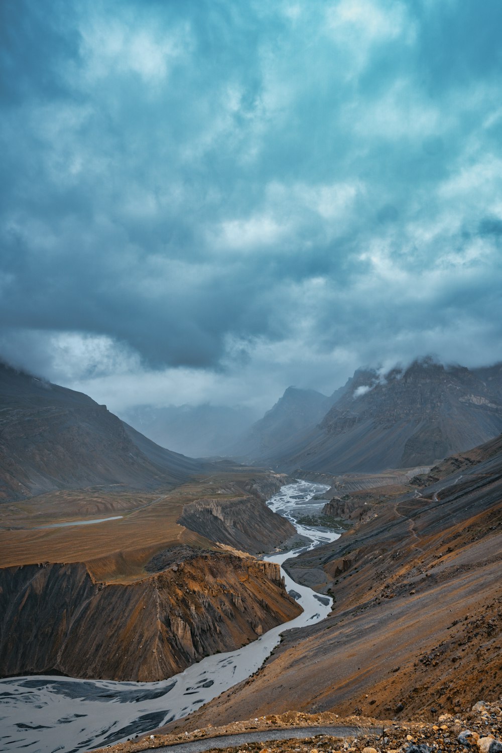 a river running through a valley surrounded by mountains