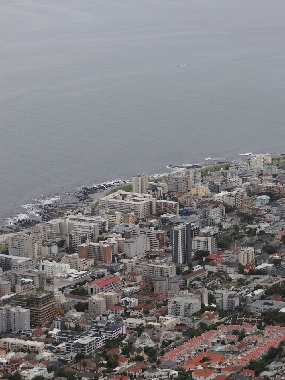 an aerial view of a city with a body of water in the background