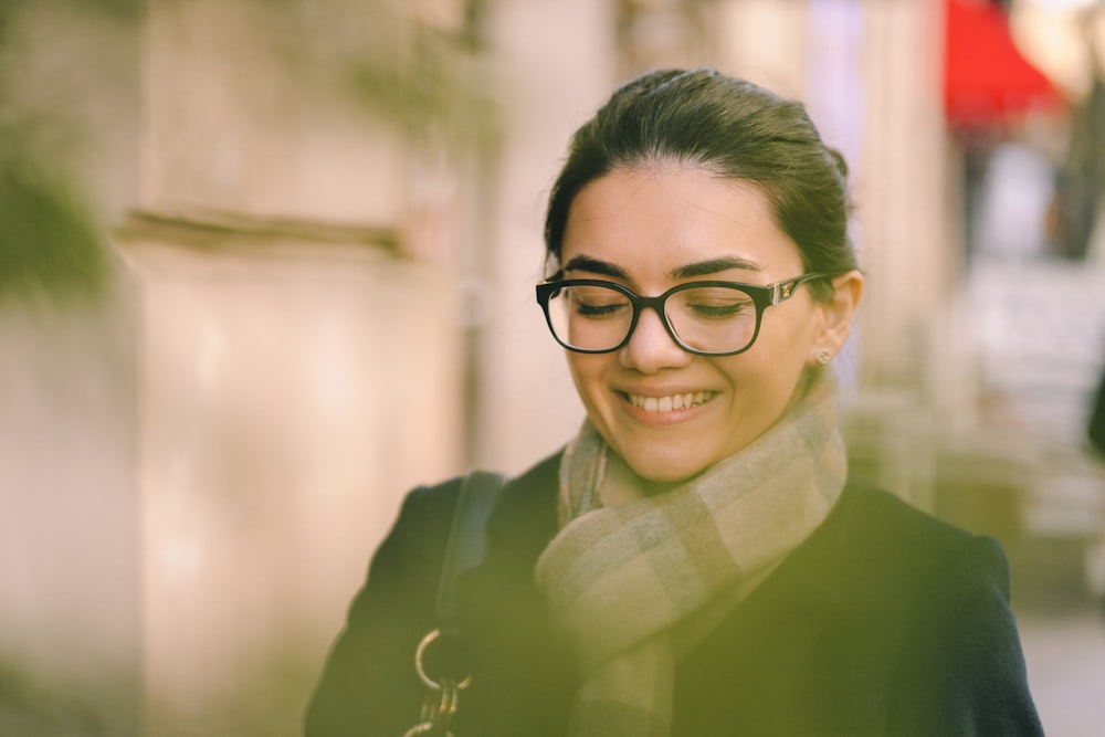 a woman wearing glasses and a scarf on a city street