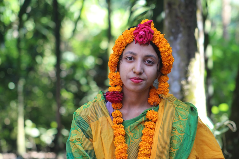 Una donna in un vestito giallo e verde con fiori tra i capelli