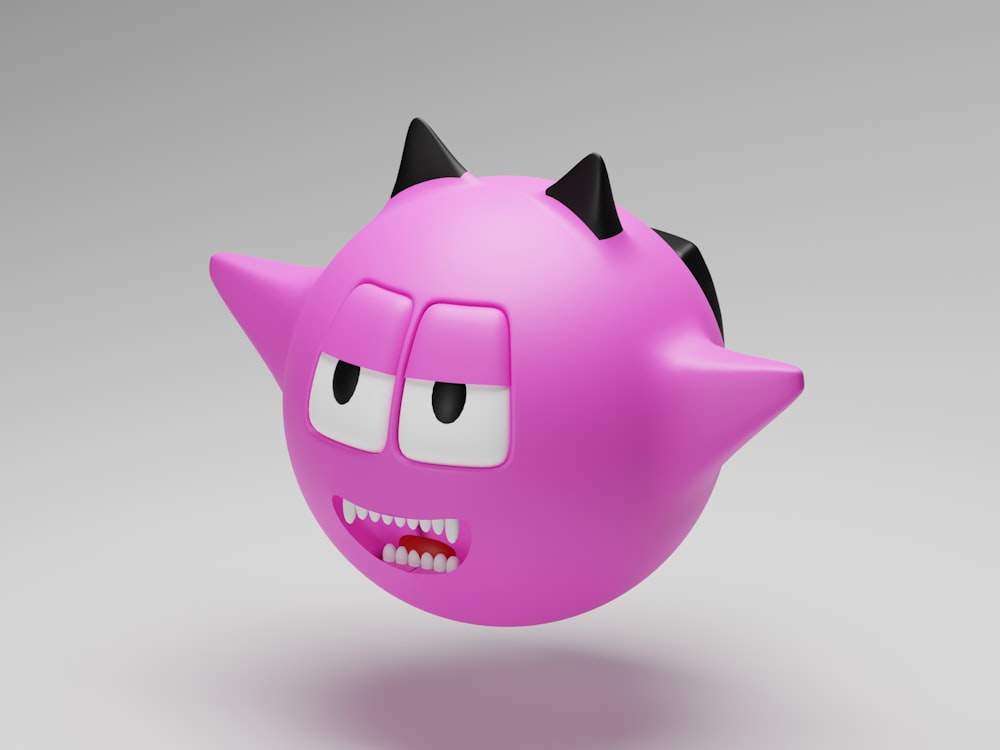 a pink ball with black ears and eyes