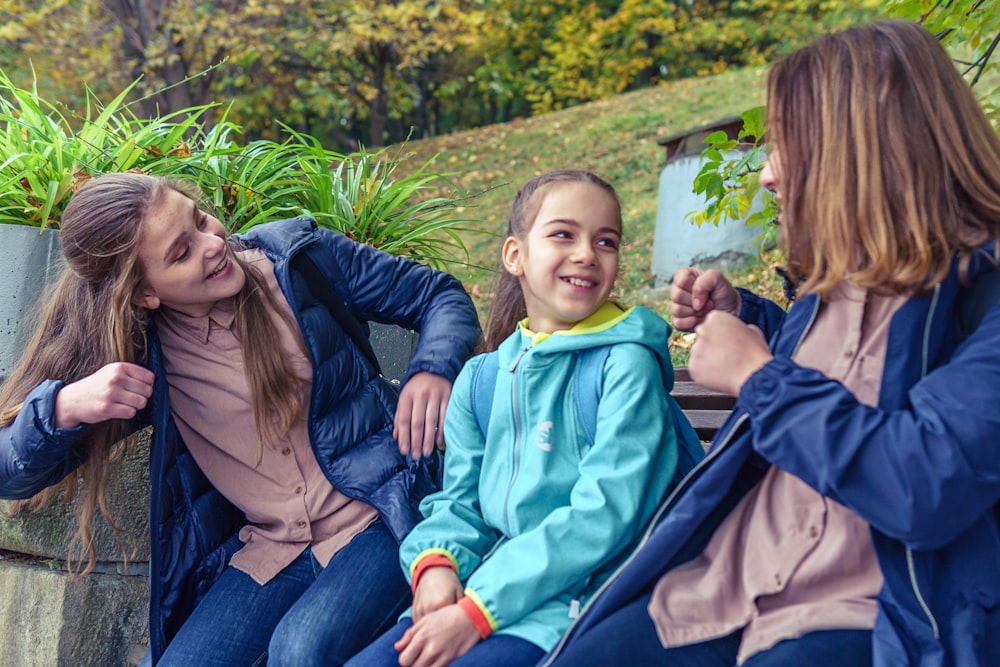 Eine Gruppe von Frauen sitzt nebeneinander auf einer Bank