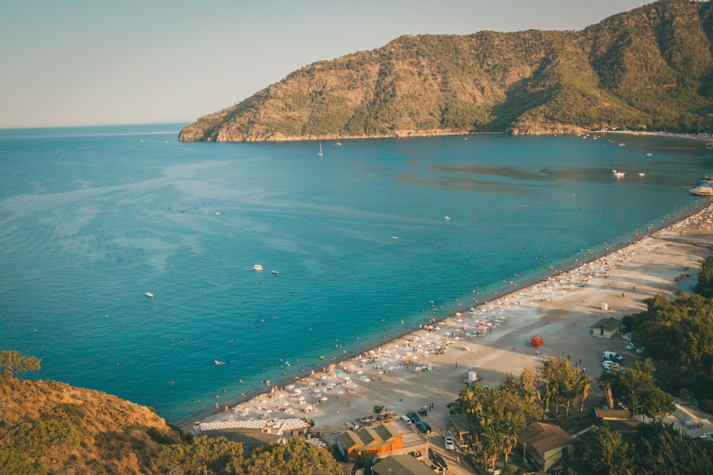 an aerial view of a beach with a mountain in the background