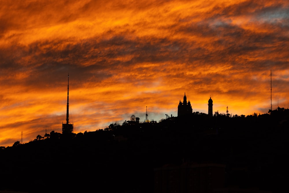 a sunset view of a city with a clock tower in the distance