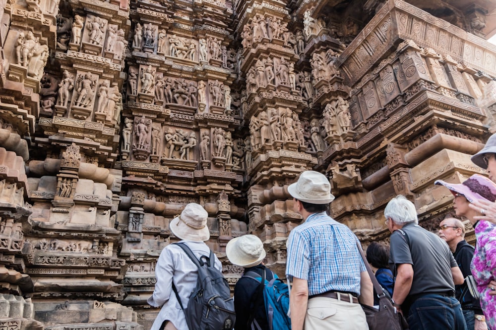 a group of people standing in front of a stone structure