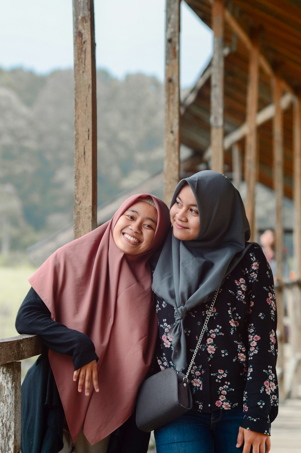 two women standing next to each other near a building