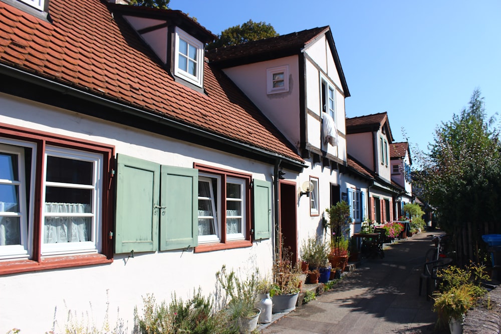 a row of white houses with green shutters