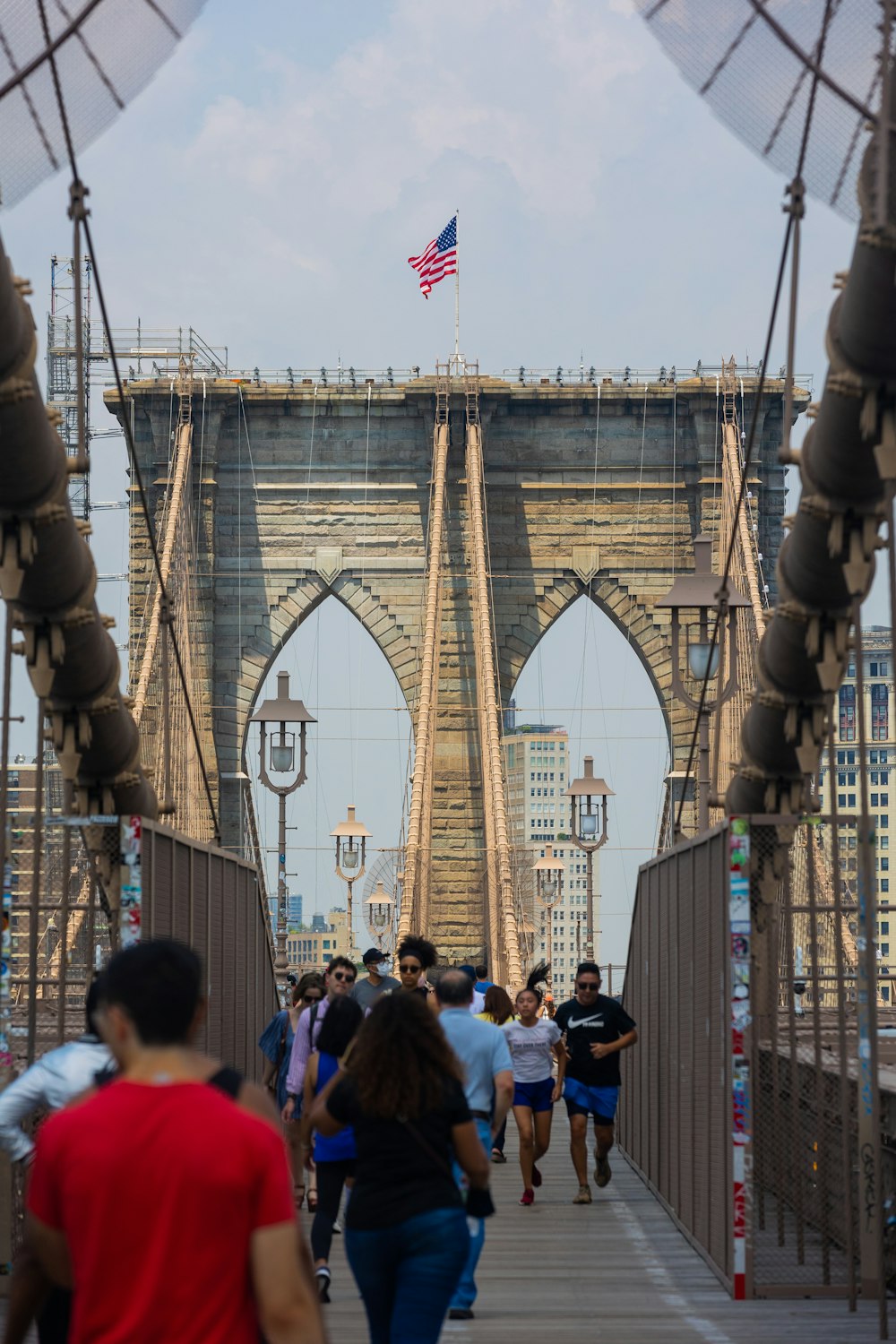 a group of people walking across a bridge