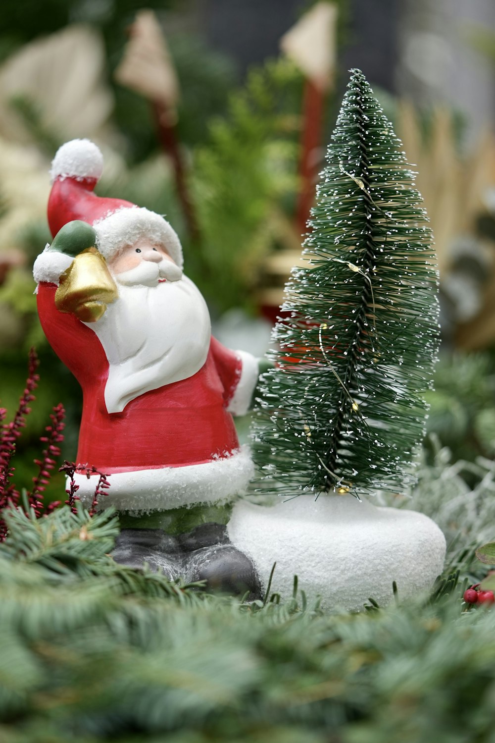 a santa clause figurine next to a christmas tree