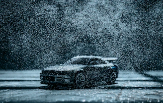 Dynamic shot of a car driving through rain, water visibly repelling off the coated surface.