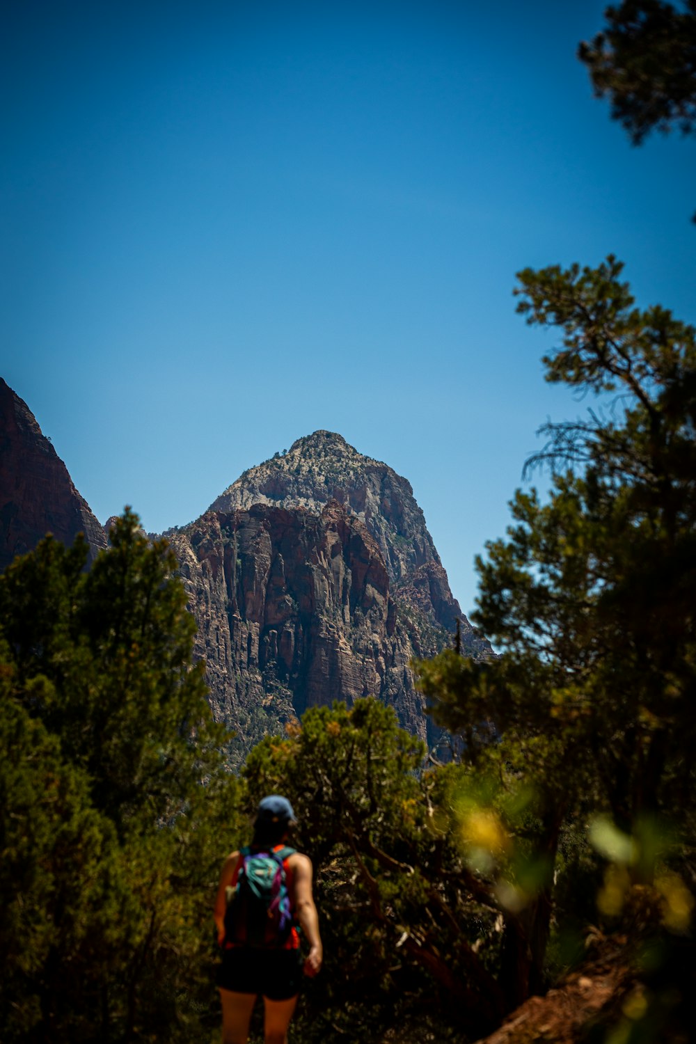 a person with a backpack walking up a trail