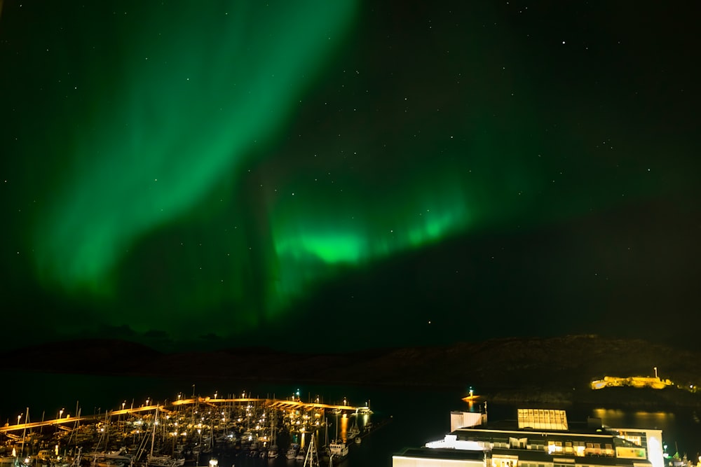 a green aurora bore over a city at night