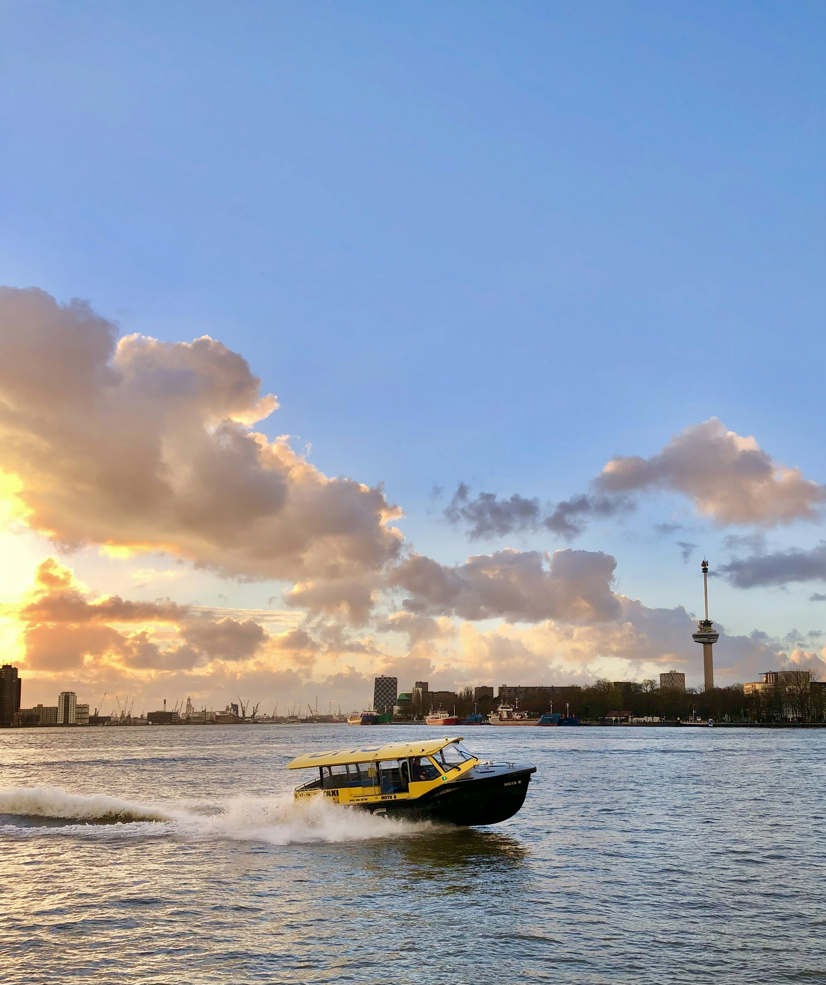 a yellow and black boat traveling across a body of water